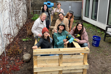 Trailblazers pose inside a raised garden bed they built