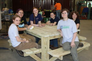 LIFT campers sitting on the picnic table they made