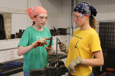Student file down metal at Rosie's Girls Weld camp