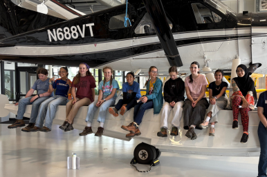 Campers pose on a plane at Rosie's Girls Aviation