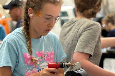 A camper practices riveting at Rosie's Girls Aviation