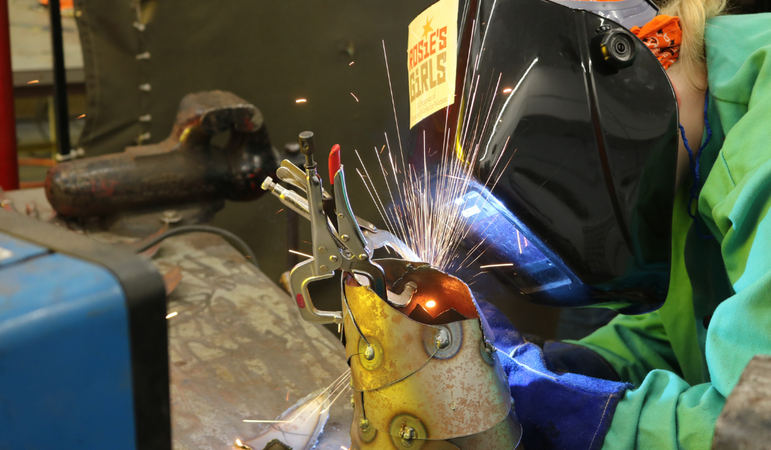 Ember welds metal as sparks fly at Rosie's Girls summer camp