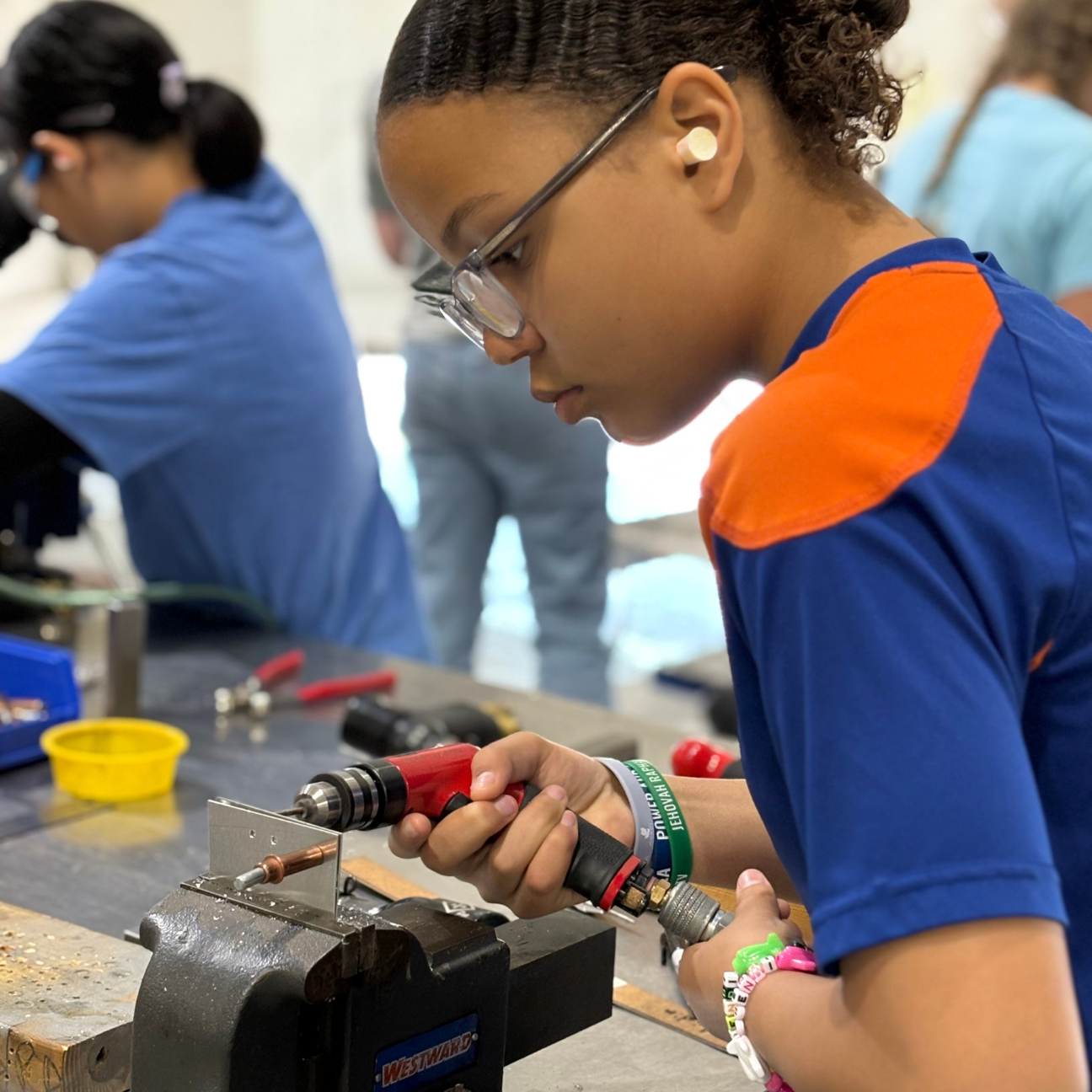 At Rosie's Girls Aviation camp, a participant rivets.