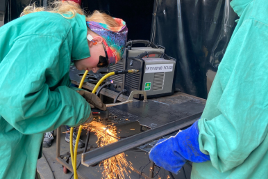 Ember uses a plasma cutter at Rosie's Girls WELD in 2023