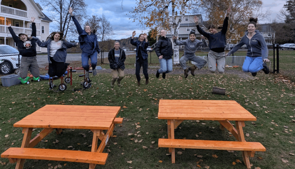 Trailblazers pose behind picnic tables they made