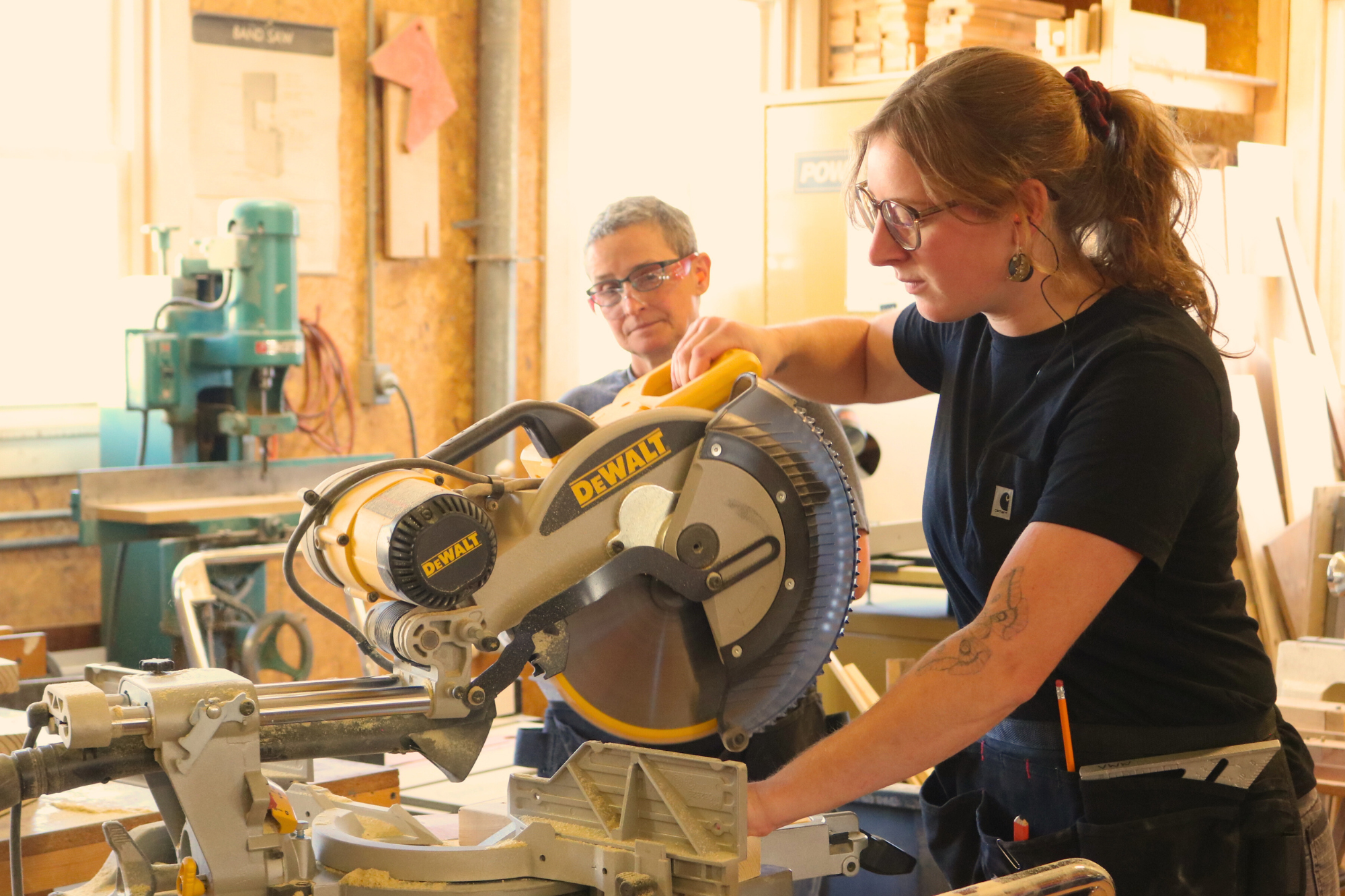 A woman uses a miter saw during the Trailblazers trades training program by Vermont Works for Women