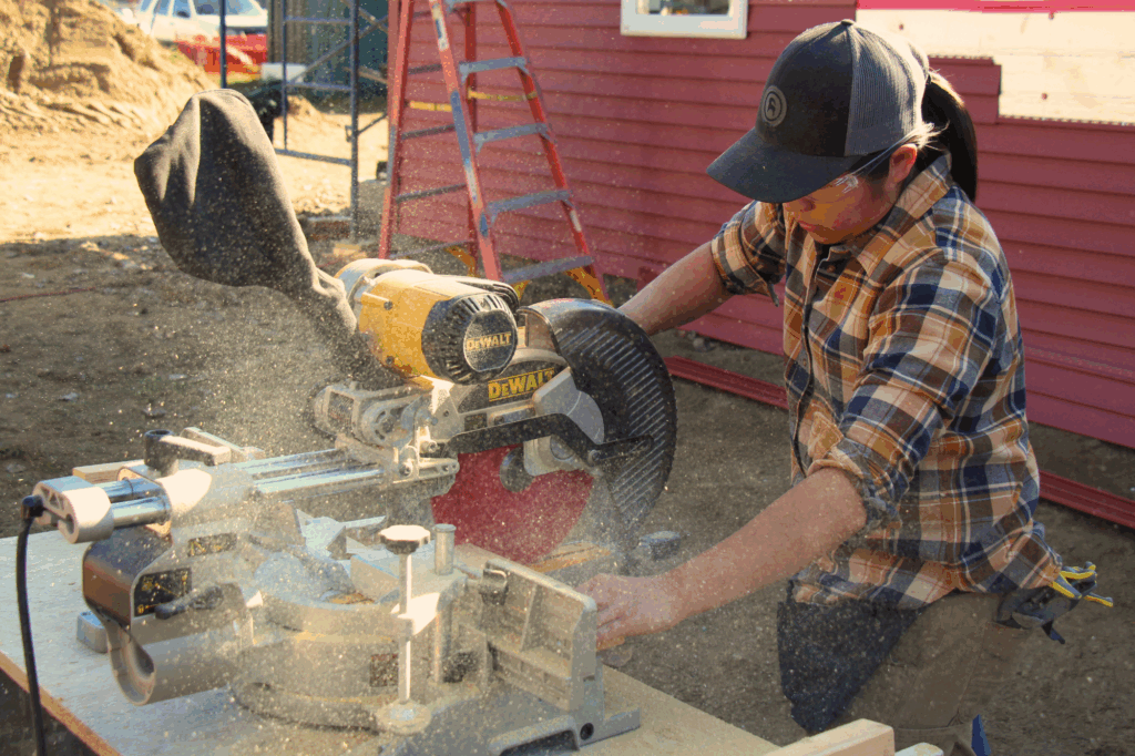 A woman uses a miter saw during the Trailblazers trades training program by Vermont Works for Women