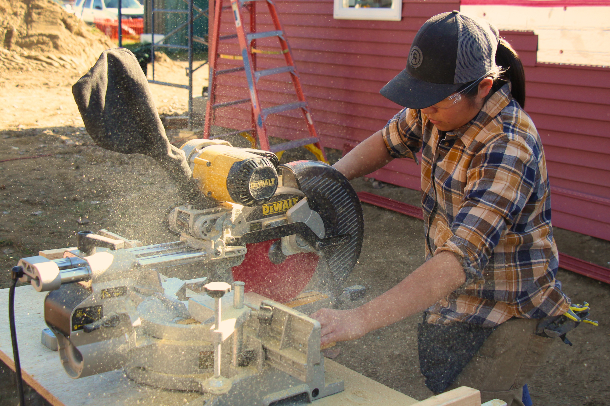 A woman uses a miter saw during the Trailblazers trades training program by Vermont Works for Women
