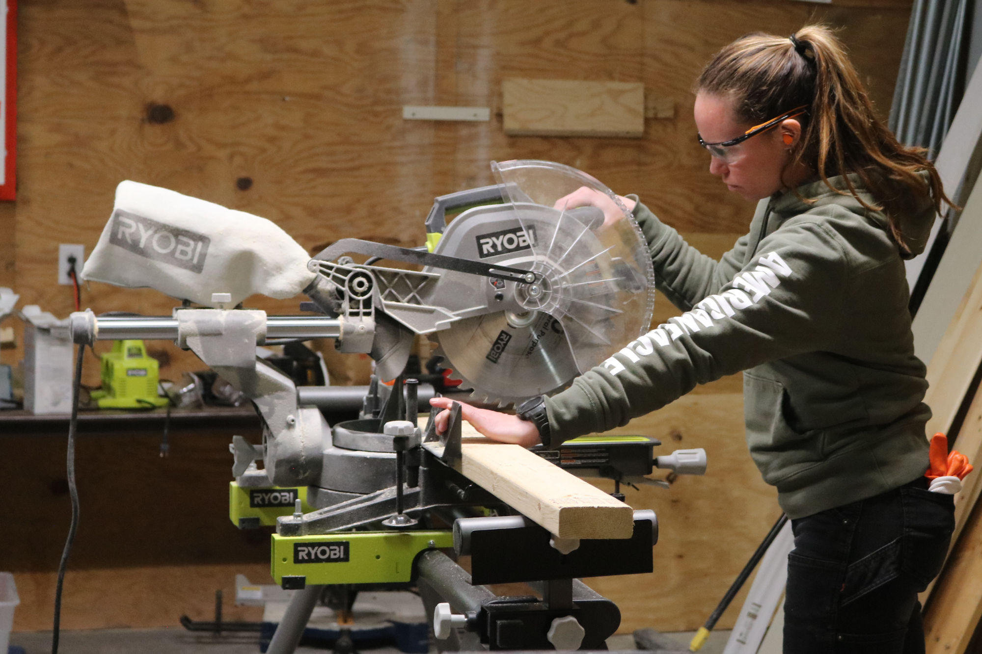 A woman uses a miter saw during the Trailblazers trades training program by Vermont Works for Women