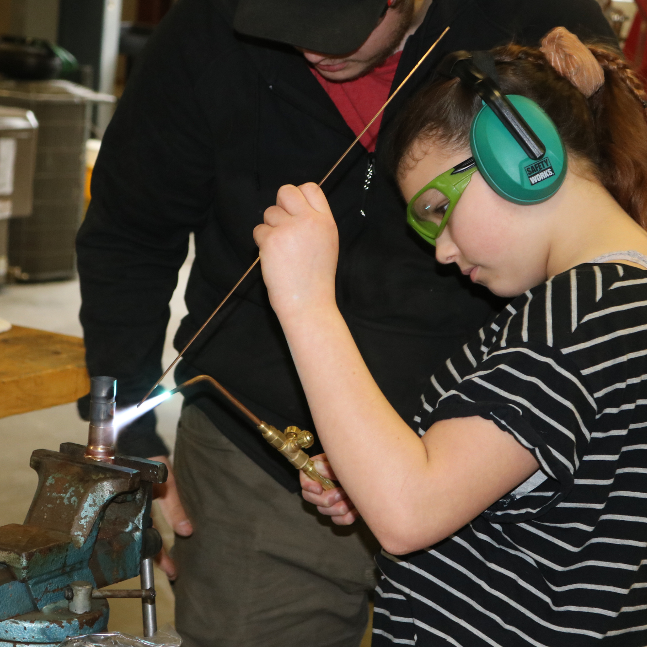 Middle school girl tries soldering metal. Introducing girls to a variety of career opportunities is part of Vermont Works for Women's overall mission.