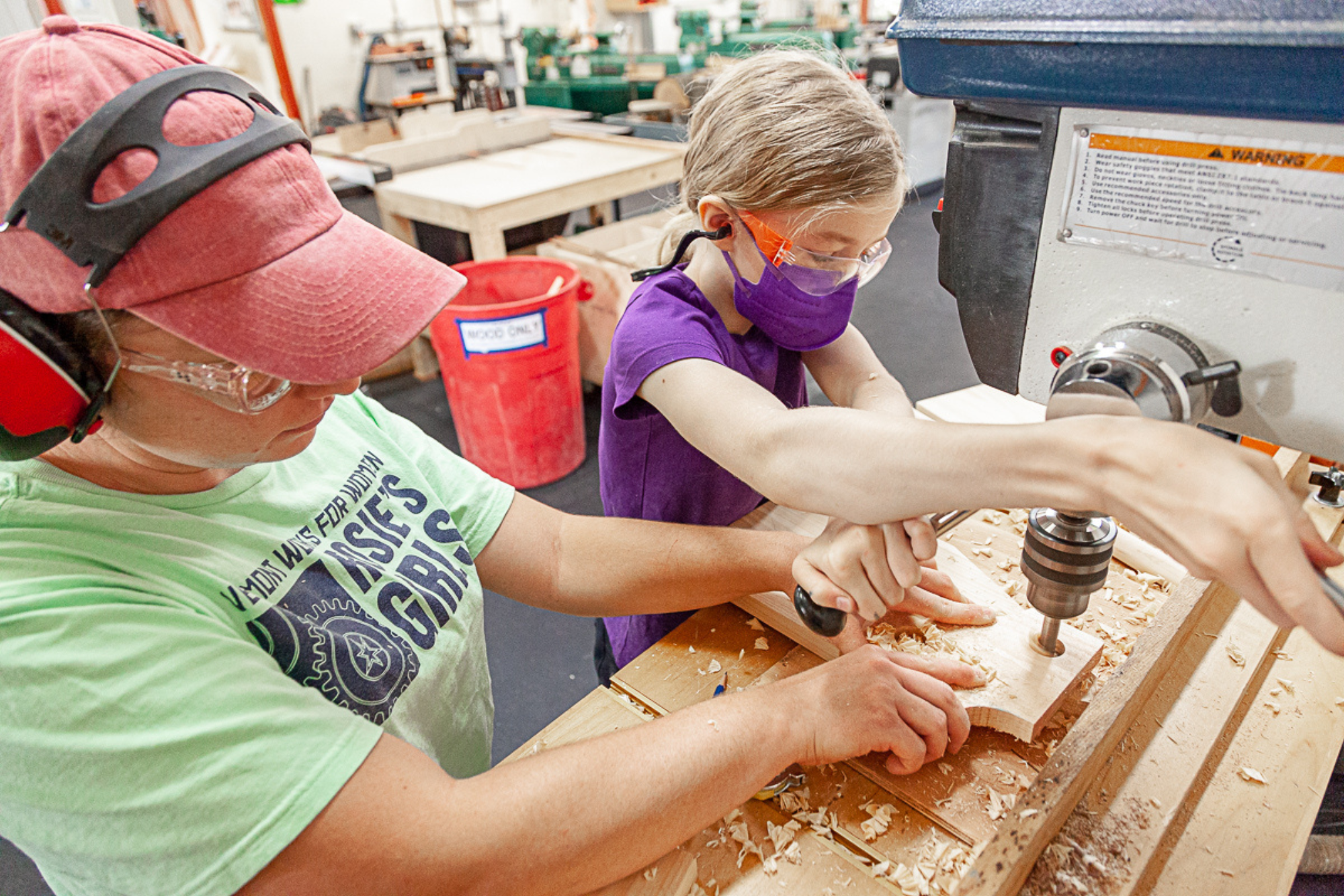 A camper uses a woodworking tool at Rosie's Girls camp at HatchSpace in Brattleboro