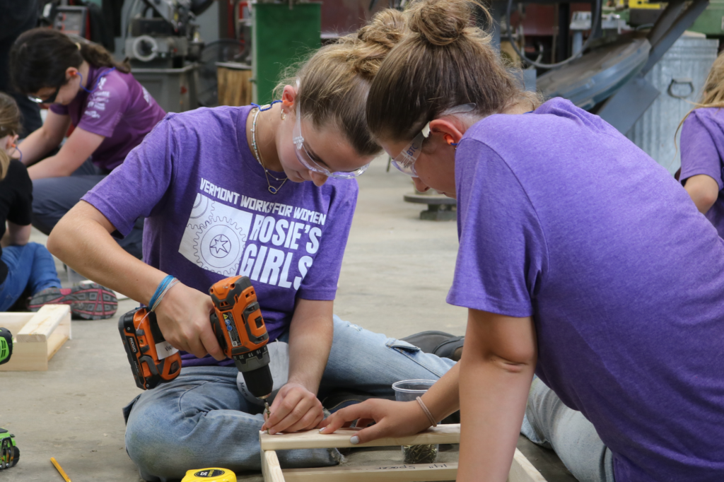 Rosie's Girls camper uses a drill at the summer trades camp