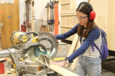A student uses a miter saw at Career Challenge Day at RTCC