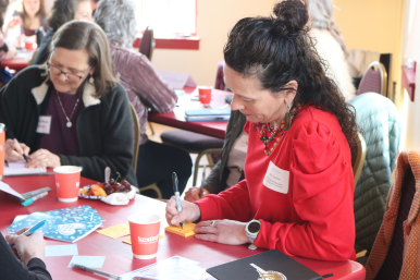 Participant writes her challenges down at the Business Through the Looking Glass networking event