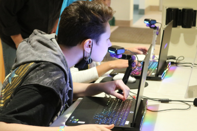 Rosie's Girls TECH camper smells OVR scent technology while playing a video game on a laptop