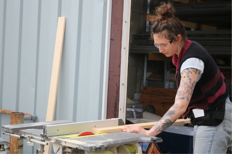 A Trailblazers participant uses a table saw to cut lumber.
