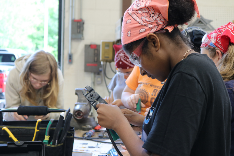 A LIFT participant strips wire during an electrical lesson