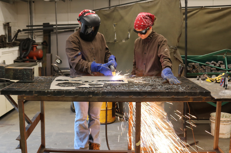 Camper at Rosie's Girls WELD uses a plasma cutter
