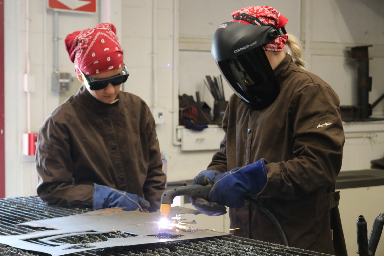 Camper at Rosie's Girls uses a plasma cutter