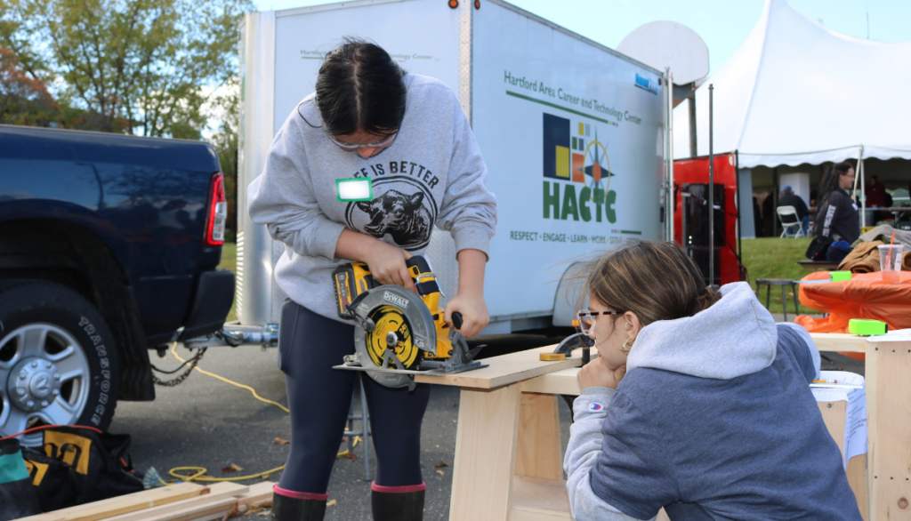Student uses a saw at Women Can Do with HACTC